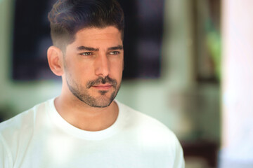 Obraz premium Close-up portrait of a handsome man standing by the window
