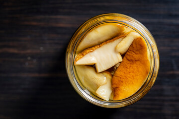 Canned white mushrooms in a glass jar, top view. Porcini mushrooms marinated in jar homemade, closeup, copy space