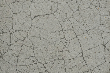 Fototapeta premium Cracked concrete surface texture with intricate lines and patterns. Ideal for grunge backgrounds, urban design, or industrial themes.