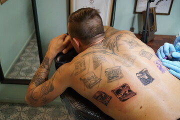 A man getting tattood at a modern classic tattoo parlor studio