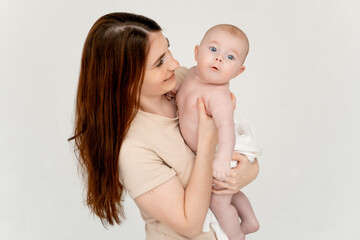 a mother with a baby on a white isolated background, a place for text, a young mother gently hugs her little child, a girl in diapers, maternal love and care