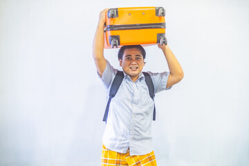 Portrait Asian muslim man carrying suitcase . Concept Going home for Eid Mubarak. Isolated image on white background