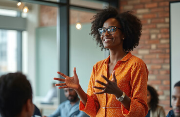 African American woman gives business presentation. Professional speaker addresses audience, shares ideas. Diverse team in meeting, corporate environment. Confident businesswoman, leadership,