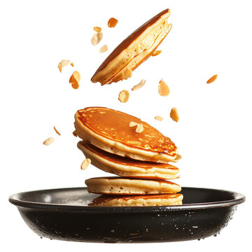 Stack of fluffy pancakes with nuts being tossed in the air above a plate