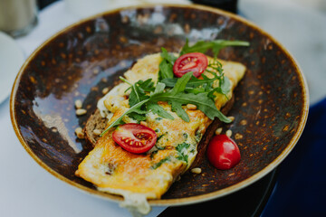 Tasty omelet infused with baby tomato and green arugula , and a light sprinkling of freshly grated Parmesan cheese.