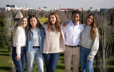 Obraz premium Front view of happy multi-ethnic students enjoying time together in a park