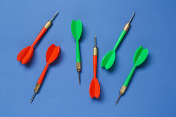 Colorful dart arrows on blue background, flat lay