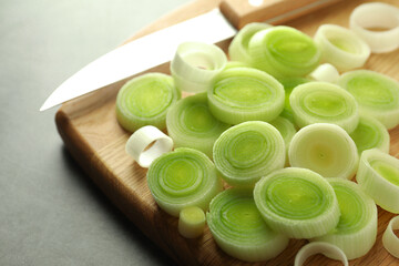 Chopped leeks and knife on grey table, closeup
