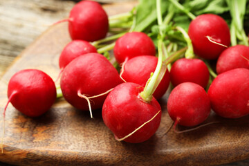 Many fresh radishes on wooden board, closeup