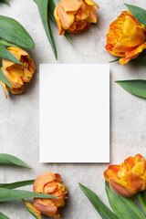 Blank invitation, flyer or greeting card mockup with tulips flowers bouquet on grey background