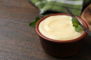 Tasty vanilla pudding, mint and pod on wooden table, closeup. Space for text