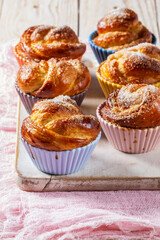 Rose-shaped yeast dough buns sprinkled with sugar in ceramic molds.