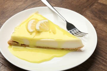 Piece of delicious cheesecake with lemon curd on wooden table, closeup