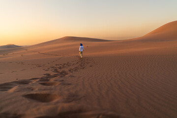 man walking on the sand dunes in sahara desert in morocco africa arabia 