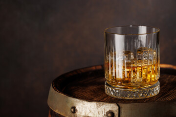 A classic whiskey glass filled with golden amber whiskey