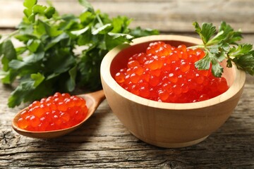 Red caviar and parsley on wooden table, closeup