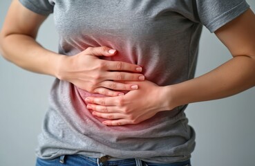 Woman with hands on stomach suffers abdominal pain. Concept of stomachache, gastritis, indigestion, bowel issues, digestive problems. Health, medical, medicine concepts. Healthcare, illness. Closeup