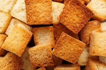 Tasty crispy croutons as background, top view