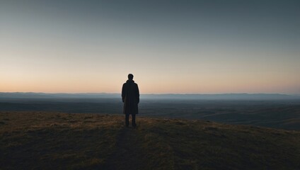 Fototapeta premium Silhouette of a Figure Overlooking a Vast Landscape at Dusk