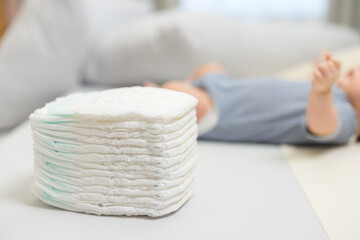 Stack of baby diapers on changing table