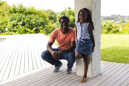 Father and daughter enjoying time together outdoors on sunny day, smiling happily
