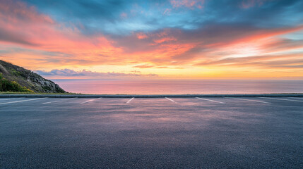 A scenic outdoor asphalt parking lot overlooking a breathtaking coastline and a sky filled with vibrant sunrise colors