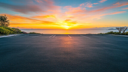 A scenic outdoor asphalt parking lot overlooking a breathtaking coastline and a sky filled with vibrant sunrise colors