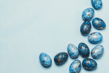 Hand painted blue golden easter eggs on blue painted table. Blue easter background.