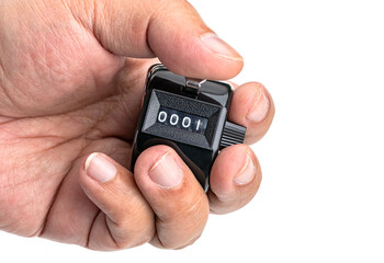 Counting forward: A hand delicately operates a hand-held tally counter, the dial reveals the number 0001. This image is a visual representation of first precision, control on white background.