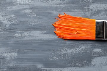 Vibrant Orange Paintbrush Stroke on Gray Wood