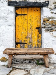 Weathered Yellow Door and Rustic Wooden Bench Against Whitewashed Stone Wall