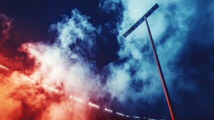 A football goalpost silhouetted against a dramatic, illuminated stadium sky, with smoke in the air.