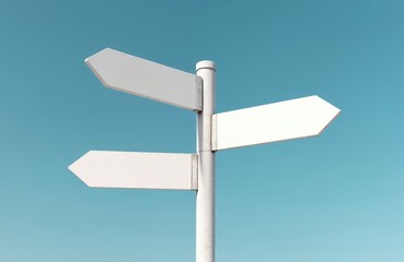 White street signs showing directions against blue sky. Signpost arrows indicate way, guide decision. Concept of choice, road, destination, travel, guidance, information, business.