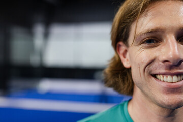 Smiling man enjoying padel tennis match, showing excitement and energy, copy space