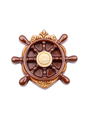 Obraz premium A decorative brown ship's wheel with ornate detailing and a central light-colored emblem isolated against a white background.