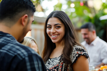 Fototapeta premium A young Hispanic woman introducing her boyfriend to her family at a lively backyard barbecue, filled with warm smiles and laughter.