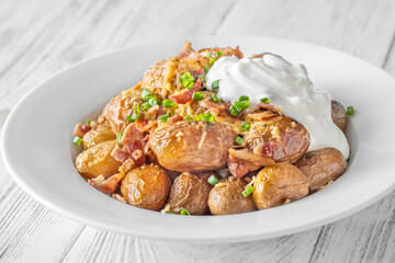 Baked baby potatoes with crispy bacon, melted cheddar, and fresh green onion