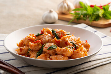 Stir Fried Thai bouncy pork meatballs (Pork patty) with holy Basil on white plate.