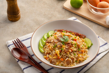 Fried Rice with Crispy Bacon.Stir fried jasmine rice with bacon carrot and eggs in white plate.