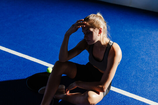 Exhausted athlete resting on court after intense padel tennis match