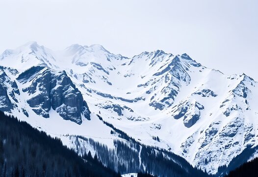 Snow-covered mountain range under a cloudy sky