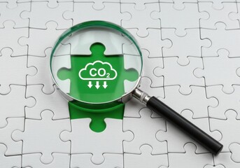 Magnifying Glass Focusing on CO2 Puzzle Piece Symbolizing Environmental Solutions and Climate Action