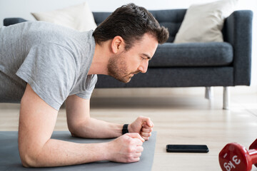 Fototapeta premium Morning fitness workout of one man at home watching video tutorial