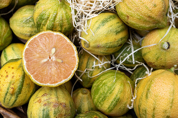 Close-up of sliced pink lemon among whole pink lemons at a market
