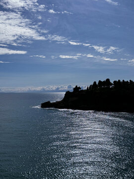 Sea shiny waters, rocky coastline and blue sky. 