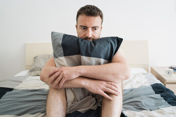 Fototapeta premium Sad and lonely man seated on his bed