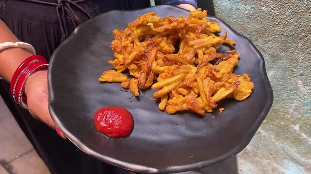 Close up shot of fried alu bhajia served with red sauce