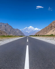 Fototapeta premium Scenic highway vanishing point in a mountainous valley under a clear blue sky