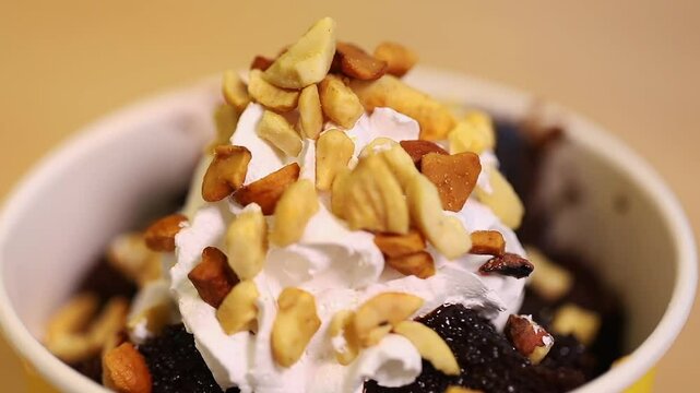 Chocolate fudge brownie ice cream with nuts on top.