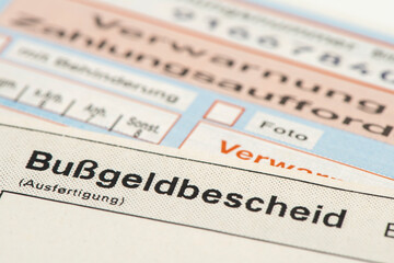 Ein Bu&szlig;geldbescheid liegt auf einem Zahlschein f&uuml;r Verkehrsversto&szlig;